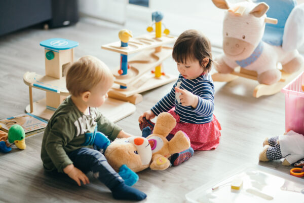 cute little girl and boy playing with toys by the home
